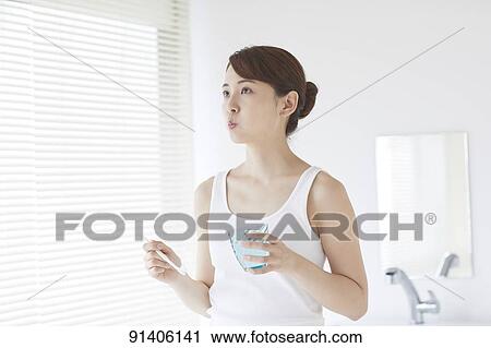 Stock Image - Young Japanese woman at home getting ready in the morning. Fotosearch
