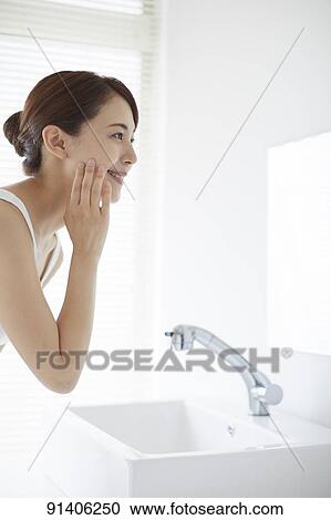 Stock Image - Young Japanese woman at home getting ready in the morning. Fotosearch