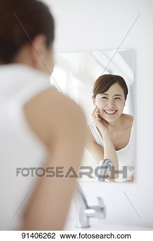 Stock Image - Young Japanese woman at home getting ready in the morning. Fotosearch