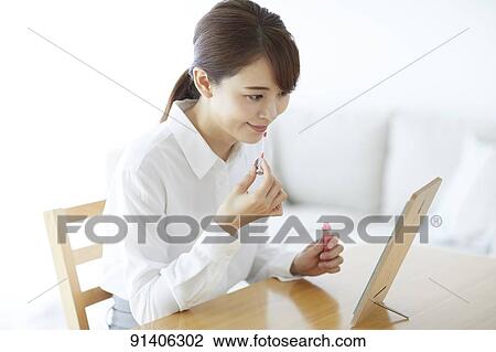 Stock Image - Young Japanese woman at home getting ready in the morning. Fotosearch