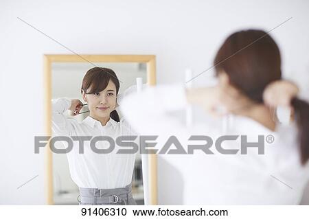 Stock Image - Young Japanese woman at home getting ready in the morning. Fotosearch