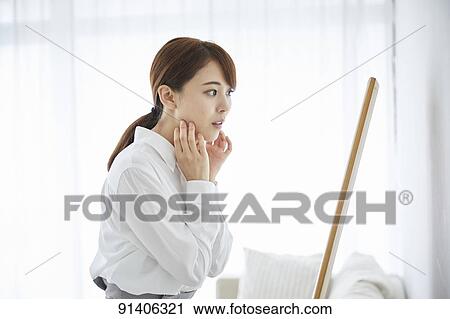 Stock Image - Young Japanese woman at home getting ready in the morning. Fotosearch