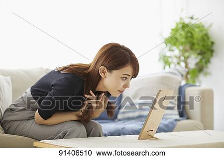 Stock Image - Young Japanese woman at home getting ready in the morning. Fotosearch