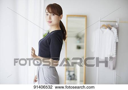 Stock Image - Young Japanese woman at home getting ready in the morning. Fotosearch