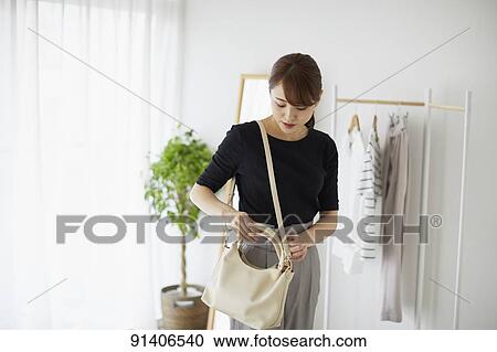 Stock Image - Young Japanese woman at home getting ready in the morning. Fotosearch