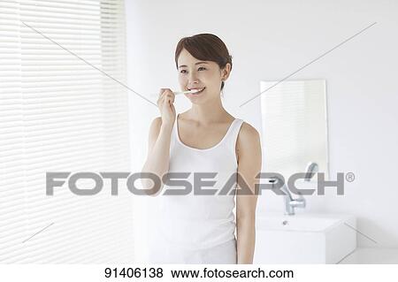 Stock Photo - Young Japanese woman at home getting ready in the morning. Fotosearch