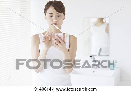 Stock Photo - Young Japanese woman at home getting ready in the morning. Fotosearch