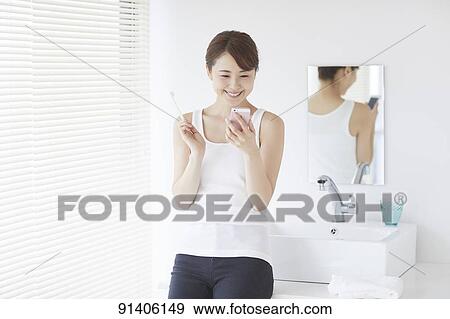 Stock Photo - Young Japanese woman at home getting ready in the morning. Fotosearch