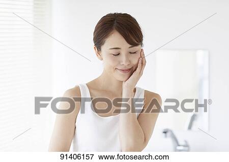Stock Photo - Young Japanese woman at home getting ready in the morning. Fotosearch