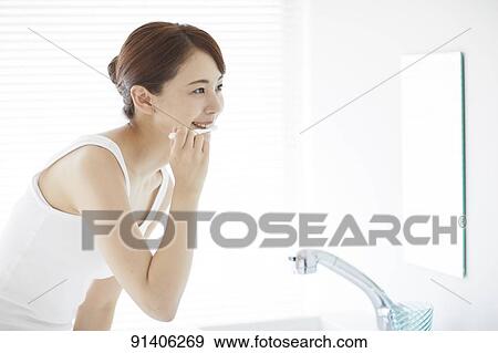 Stock Photo - Young Japanese woman at home getting ready in the morning. Fotosearch