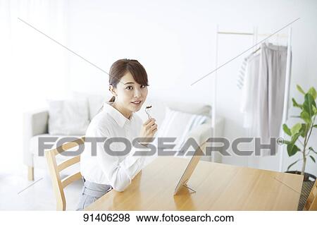 Stock Photo - Young Japanese woman at home getting ready in the morning. Fotosearch