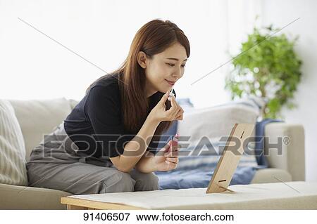 Stock Photo - Young Japanese woman at home getting ready in the morning. Fotosearch