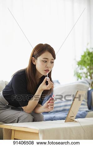 Stock Photo - Young Japanese woman at home getting ready in the morning. Fotosearch