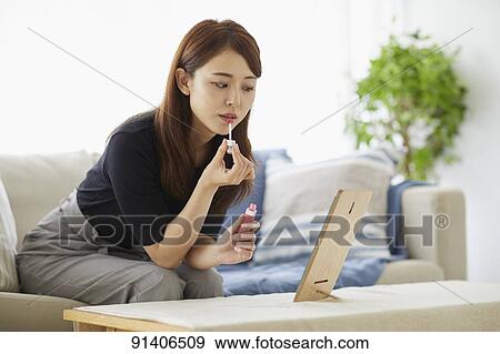 Stock Photo - Young Japanese woman at home getting ready in the morning. Fotosearch