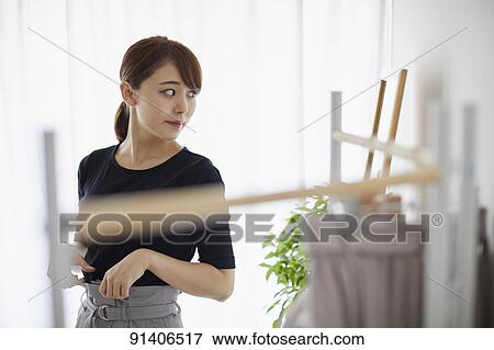 Stock Photo - Young Japanese woman at home getting ready in the morning. Fotosearch