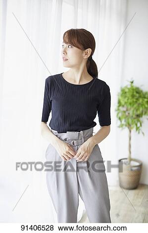 Stock Photo - Young Japanese woman at home getting ready in the morning. Fotosearch