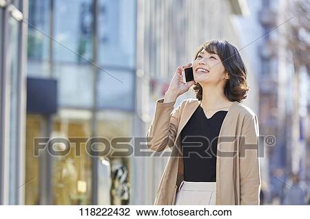 Stock Image - Young Japanese woman downtown Tokyo. Fotosearch