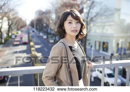 Stock Image - Young Japanese woman downtown Tokyo. Fotosearch
