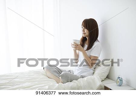 Stock Photo - Young Japanese woman in bed in the morning. Fotosearch