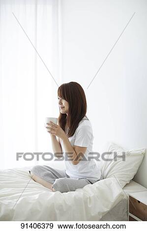 Stock Photo - Young Japanese woman in bed in the morning. Fotosearch