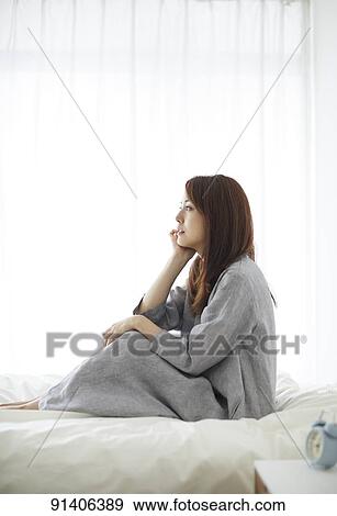 Stock Photo - Young Japanese woman in bed in the morning. Fotosearch