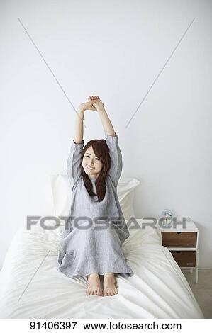 Stock Photo - Young Japanese woman in bed in the morning. Fotosearch
