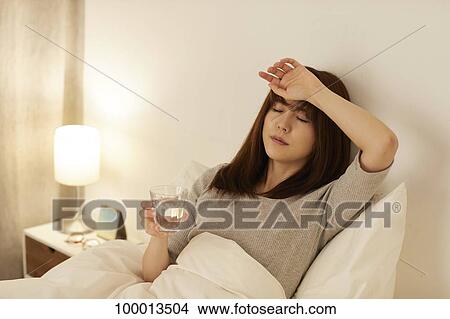 Picture - Young Japanese woman in bed. Fotosearch