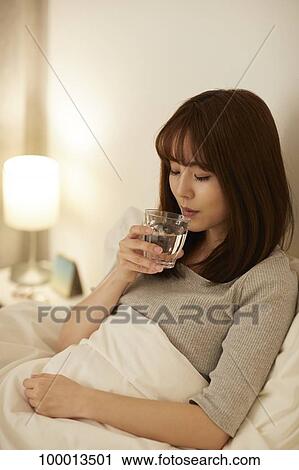 Stock Image - Young Japanese woman in bed. Fotosearch
