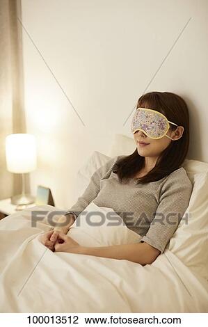 Stock Image - Young Japanese woman in bed. Fotosearch