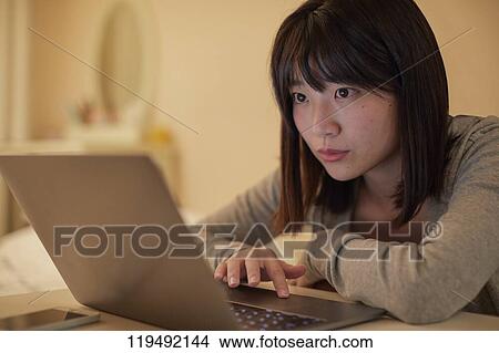 Picture - Young Japanese woman in her house. Fotosearch