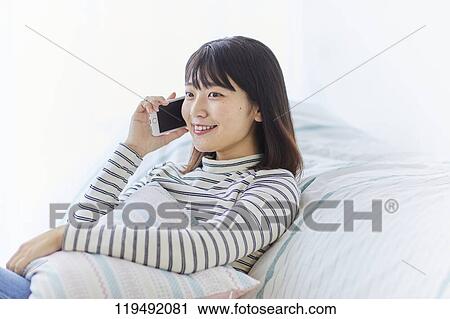 Stock Image - Young Japanese woman in her house. Fotosearch