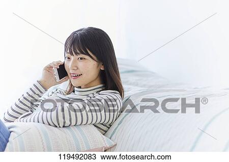 Stock Image - Young Japanese woman in her house. Fotosearch