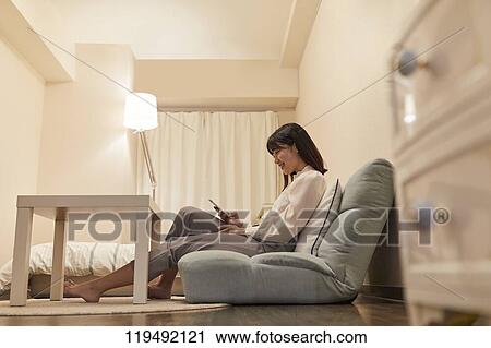 Stock Image - Young Japanese woman in her house. Fotosearch