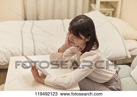 Stock Image - Young Japanese woman in her house. Fotosearch