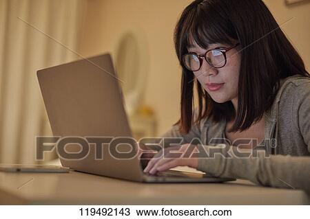 Stock Image - Young Japanese woman in her house. Fotosearch