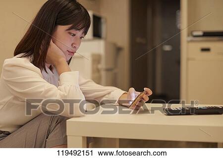 Stock Image - Young Japanese woman in her house. Fotosearch