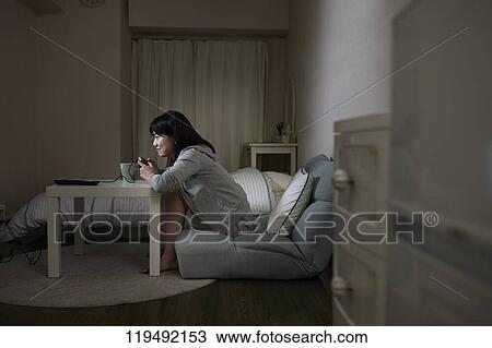 Stock Image - Young Japanese woman in her house. Fotosearch