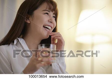 Picture - Young Japanese woman in the living room. Fotosearch