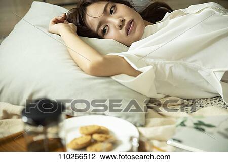 Stock Image - Young Japanese woman in the living room. Fotosearch