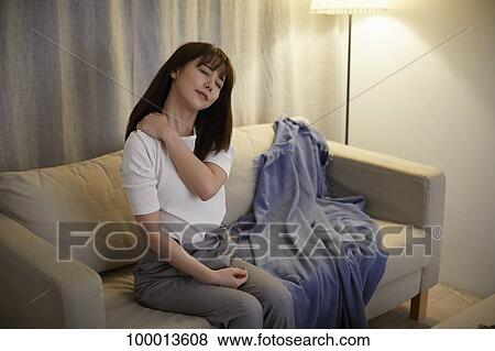 Stock Photo - Young Japanese woman in the living room. Fotosearch