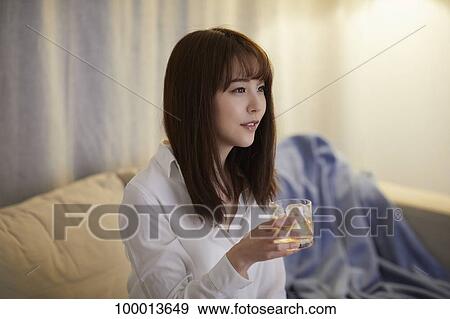 Stock Photo - Young Japanese woman in the living room. Fotosearch