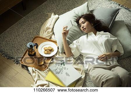 Stock Photo - Young Japanese woman in the living room. Fotosearch