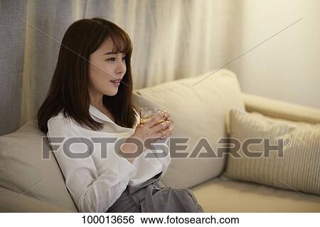 Stock Photograph - Young Japanese woman in the living room. Fotosearch