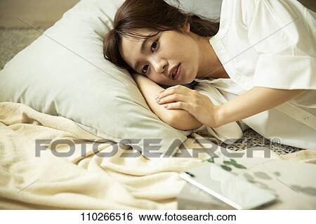 Stock Photograph - Young Japanese woman in the living room. Fotosearch