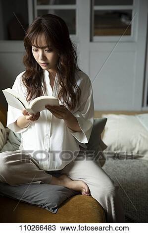 Stock Image - Young Japanese woman on the sofa. Fotosearch