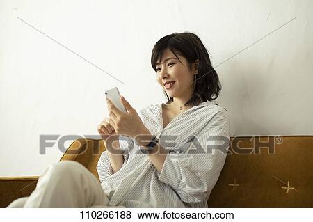 Young Japanese woman on the sofa View Large Photo Image Stock Photo - Young Japanese woman on the sofa. Fotosearch