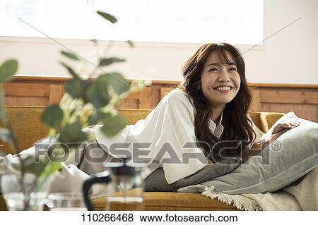 Stock Photo - Young Japanese woman on the sofa. Fotosearch