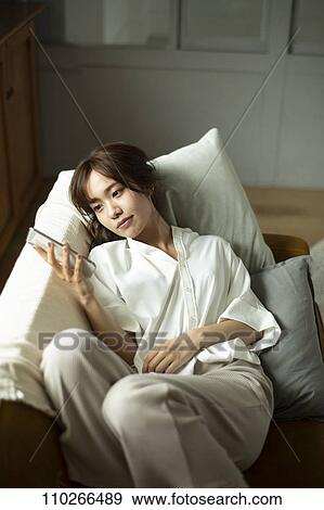 Young Japanese woman on the sofa View Large Photo Image Stock Photo - Young Japanese woman on the sofa. Fotosearch