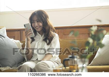 Young Japanese woman on the sofa View Large Photo Image Stock Photograph - Young Japanese woman on the sofa. Fotosearch