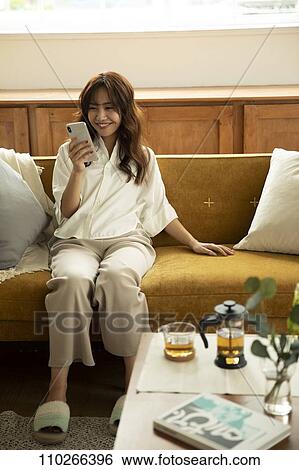 Stock Photograph - Young Japanese woman on the sofa. Fotosearch